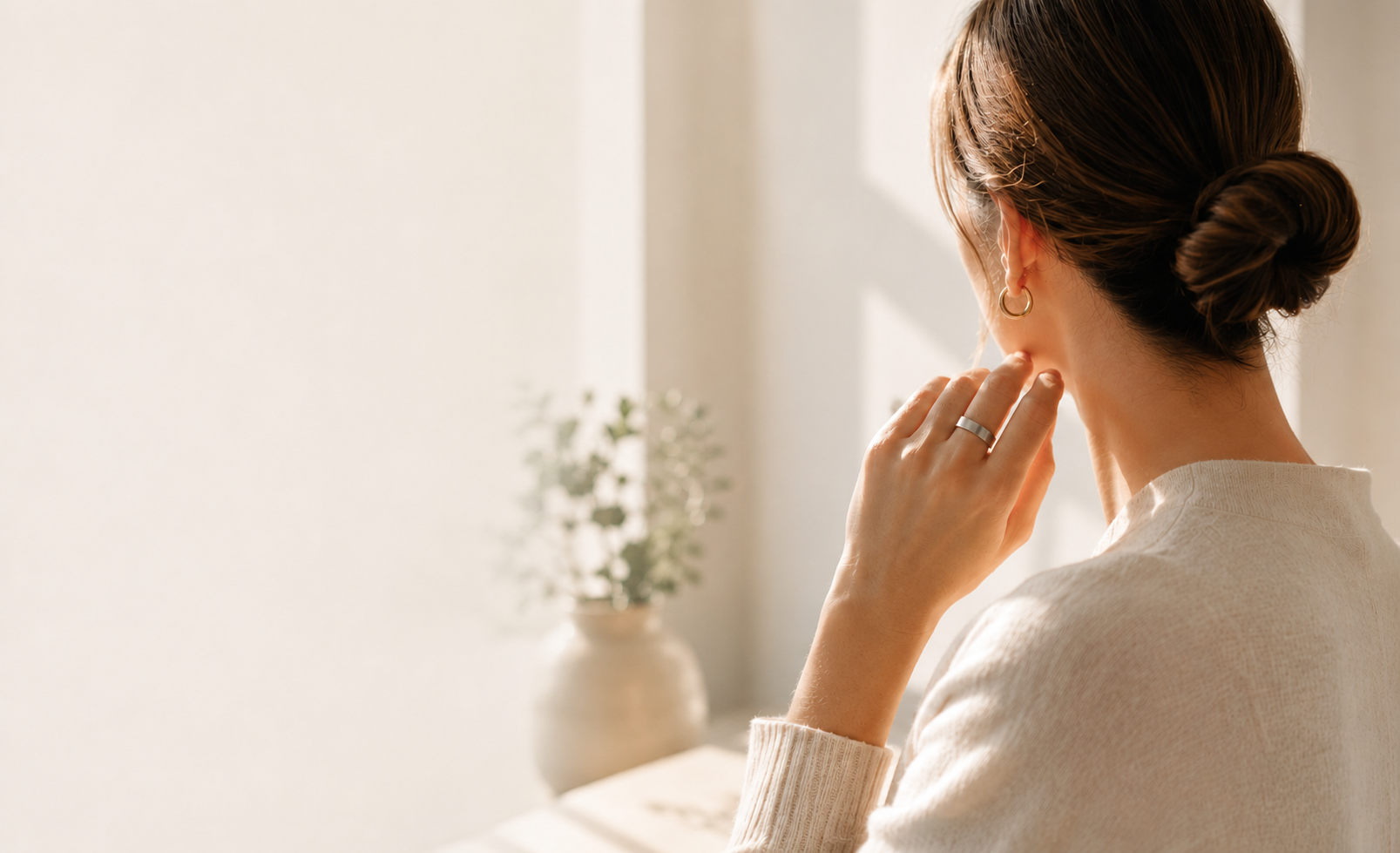 Woman wearing the Nerals pressure-point ring in soft morning light